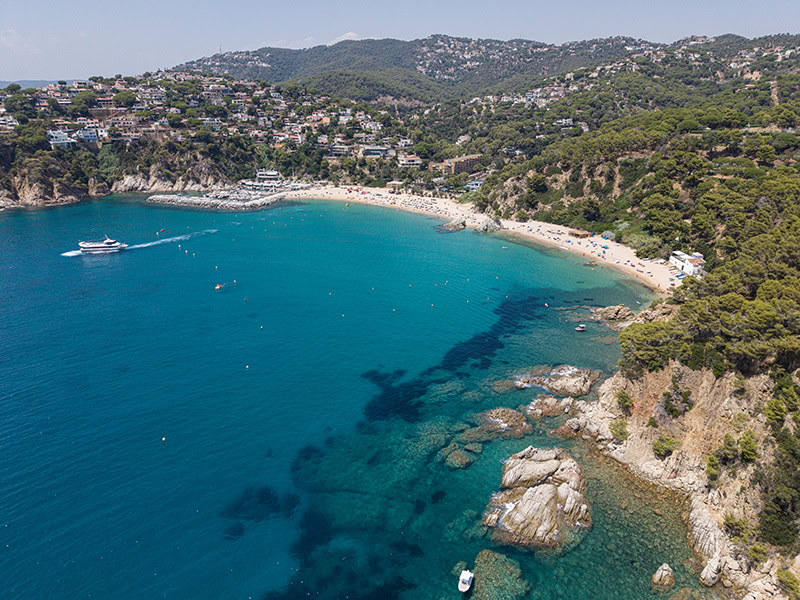 restaurante-sybius-cala-canyelles-lloret-de-mar-costa-brava Vista panorámica de Cala Canyelles en Lloret de Mar, Costa Brava, junto al Restaurante Sybius y las aguas cristalinas del Mediterráneo. Vista panoràmica de Cala Canyelles a Lloret de Mar, Costa Brava, al costat del Restaurant Sybius i de les aigües cristal·lines de la Mediterrània. Panoramic view of Cala Canyelles in Lloret de Mar on the Costa Brava, next to Sybius Restaurant and the crystal-clear Mediterranean Sea. Vue panoramique de Cala Canyelles à Lloret de Mar, sur la Costa Brava, à proximité du Restaurant Sybius et des eaux cristallines de la Méditerranée.